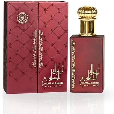 Ard Al Zaafaran Ahlam Al Khaleej 80ml by Ard Al Zaafaran — A red perfume box with gold intricate patterns and a matching red perfume bottle with a gold cap, displayed side-by-side on a white reflective surface. | Ard Al Zaafaran Ahlam Al Khaleej 80ml by Ard Al Zaafaran — Kotak minyak wangi merah dengan corak emas yang