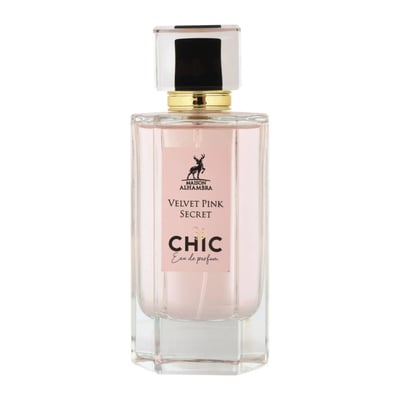 Maison Alhambra Chic Velvet Pink Secret for Women 100ml — A pink cylindrical box stands next to a clear glass perfume bottle with a black cap and gold accents. The box and bottle label feature a deer silhouette and text. | Maison Alhambra Chic Velvet Pink Secret for Women 100ml — Kotak silinder merah jambu berdiri di