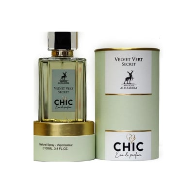 Maison Alhambra Chic Velvet Vert Secret 100ml — A cylindrical light green box with gold trim stands next to a clear glass perfume bottle with a green label and a silver and black cap. | Maison Alhambra Chic Velvet Vert Secret 100ml — Kotak silinder hijau muda dengan trim emas berdiri di sebelah botol minyak wangi kaca