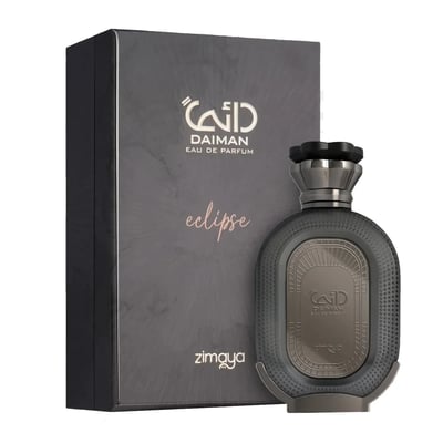 Zimaya Daiman Eclipse Eau De Parfum 100ml — A dark grey perfume bottle with a textured body and a metallic cap stands next to its matching dark grey box with Arabic calligraphy and text. | Zimaya Daiman Eclipse Eau De Parfum 100ml — Botol minyak wangi kelabu gelap dengan badan bertekstur dan penutup logam berdiri