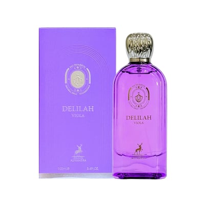 Maison Alhambra Delilah Viola 100ml — A purple glass perfume bottle with a gold cap stands next to its matching purple box, both featuring gold embossed details and a deer logo. | Maison Alhambra Delilah Viola 100ml — Botol kaca ungu berdiri di sebelah kotak ungu sepadan, kedua-duanya menampilkan butiran emas timbul