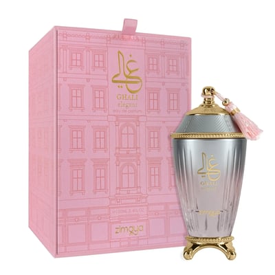 Zimaya Ghali Elegant Eau De Parfum 100ml by Zimaya — A pink patterned box with building facade design stands next to a fluted glass perfume bottle with a gold base and a pink tassel on the cap. | Zimaya Ghali Elegant Eau De Parfum 100ml oleh Zimaya — Peti merah jambu bercorak dengan reka bentuk fasad bangunan berdiri