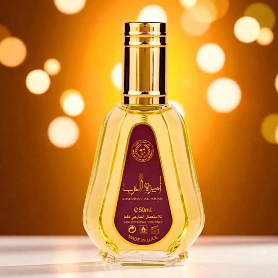 Ard Al Zaafaran Ameerat Al Arab Princess of Arabia 50ml — A red and gold perfume box stands next to a clear glass perfume bottle with a gold cap and a red label. | Ard Al Zaafaran Ameerat Al Arab Princess of Arabia 50ml — Kotak minyak wangi merah dan emas berdiri di sebelah botol minyak wangi kaca jernih dengan