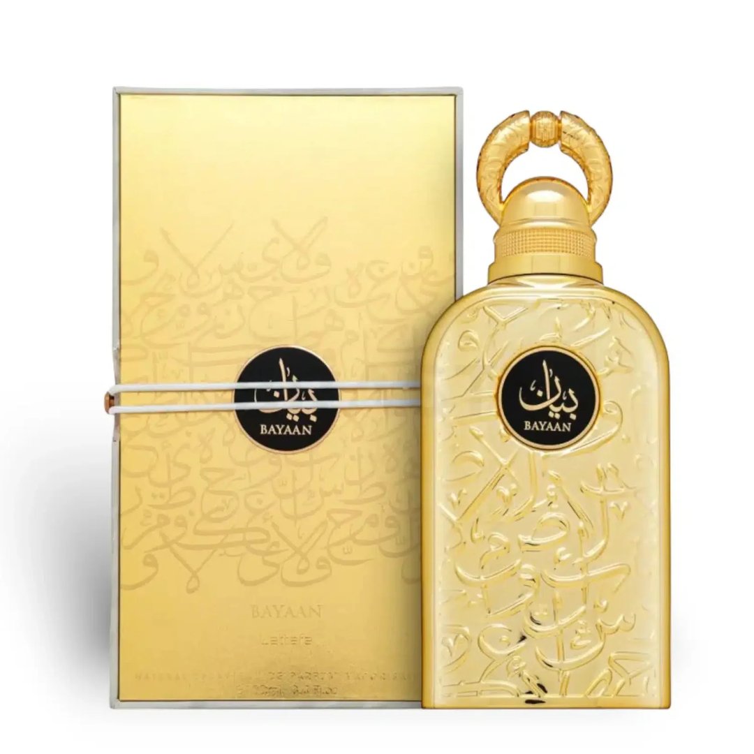 Lattafa Bayaan Eau De Parfum — A gold-colored perfume bottle with ornate Arabic script and a gold ring handle sits next to its matching gold box, also adorned with script and a circular logo. | Lattafa Bayaan Eau De Parfum — Botol minyak wangi berwarna emas dengan skrip Arab berhias dan pemegang cincin emas duduk