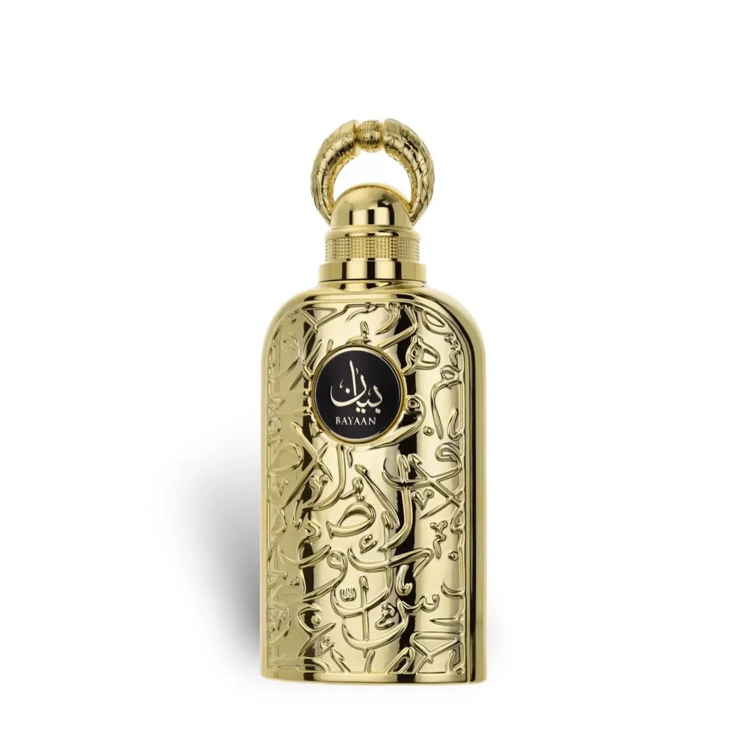 Lattafa Bayaan Eau De Parfum — A gold-colored perfume bottle with ornate Arabic script and a gold ring handle sits next to its matching gold box, also adorned with script and a circular logo. | Lattafa Bayaan Eau De Parfum — Botol minyak wangi berwarna emas dengan skrip Arab berhias dan pemegang cincin emas duduk