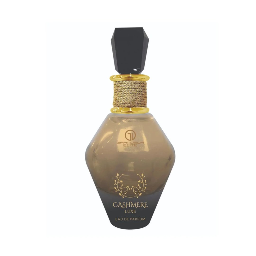 Grandeur Cashmere Luxe 100ml by Grandeur — A faceted glass perfume bottle with a black gem-like cap and a black tassel hanging from the neck, against a white background. | Grandeur Cashmere Luxe 100ml by Grandeur — Botol kaca berfaset dengan penutup seperti permata hitam dan juntai hitam tergantung di lehernya