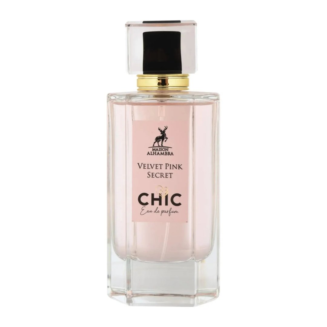 Maison Alhambra Chic Velvet Pink Secret for Women 100ml — A pink cylindrical box stands next to a clear glass perfume bottle with a black cap and gold accents. The box and bottle label feature a deer silhouette and text. | Maison Alhambra Chic Velvet Pink Secret for Women 100ml — Kotak silinder merah jambu berdiri di