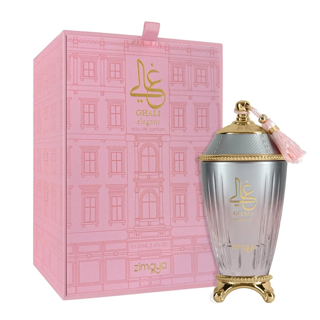 Zimaya Ghali Elegant Eau De Parfum 100ml by Zimaya — A pink patterned box with building facade design stands next to a fluted glass perfume bottle with a gold base and a pink tassel on the cap. | Zimaya Ghali Elegant Eau De Parfum 100ml oleh Zimaya — Peti merah jambu bercorak dengan reka bentuk fasad bangunan berdiri