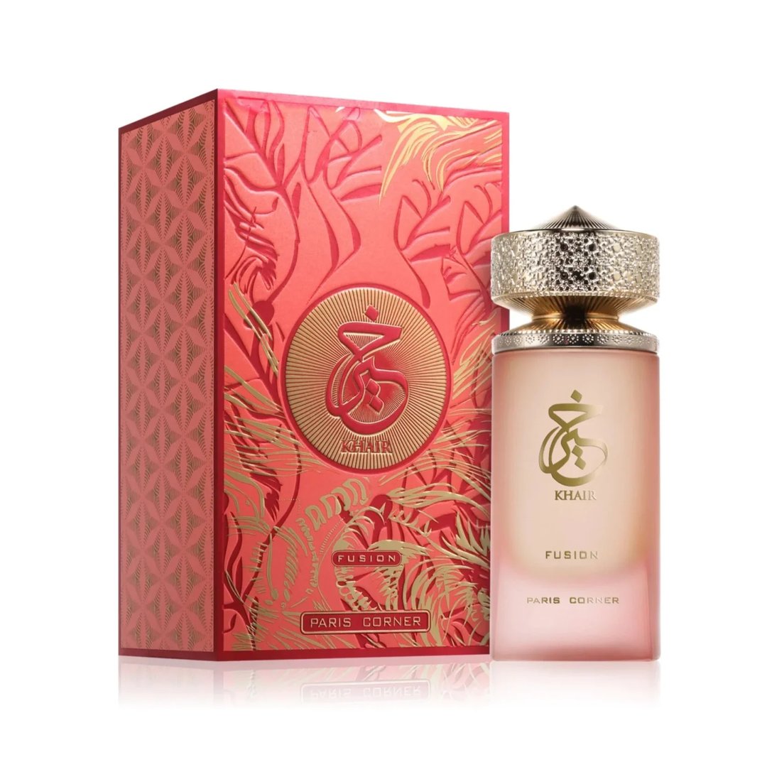 Paris Corner Khair Fusion Her 100ml — Red and gold patterned box next to a frosted pink perfume bottle with a gold textured cap. | Paris Corner Khair Fusion Her 100ml — Kotak corak merah dan emas di sebelah botol minyak wangi merah jambu beku dengan penutup bertekstur emas.
