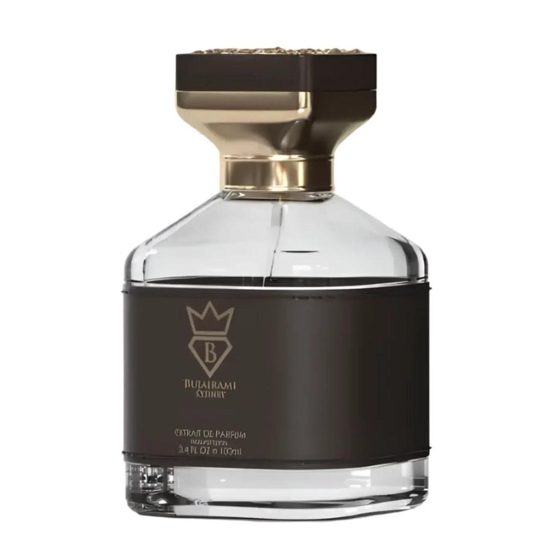 Bujairami Kingsman — A clear glass perfume bottle with a black leather band and gold accents sits next to its dark brown