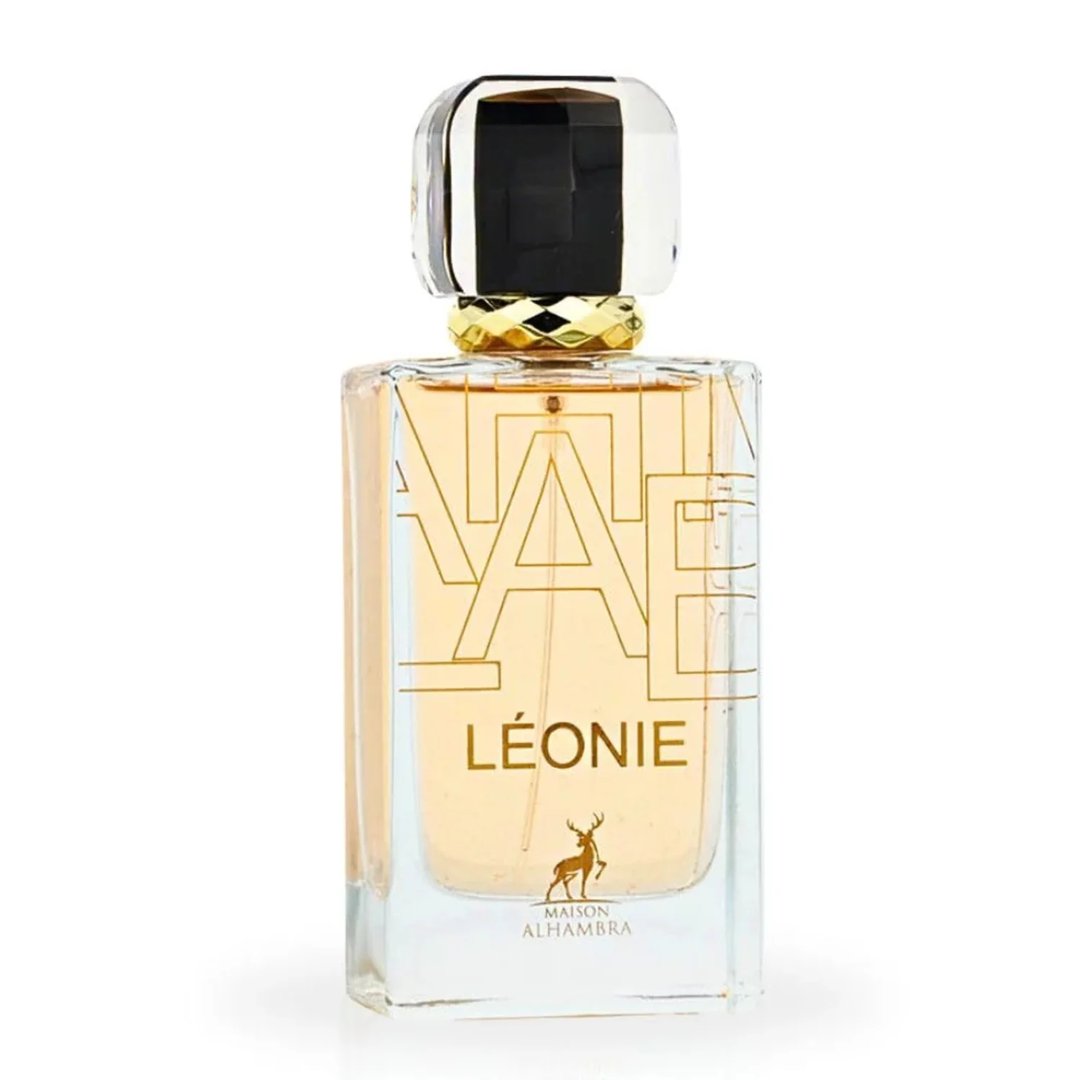 Maison Alhambra Leonie for Women by Maison Alhambra 100ml — A perfume bottle and its box are displayed side-by-side against a white background. The box is black and white with gold lettering and a deer logo. The bottle is clear glass with gold lettering and a deer logo. | Maison Alhambra Leonie for Women by Maison