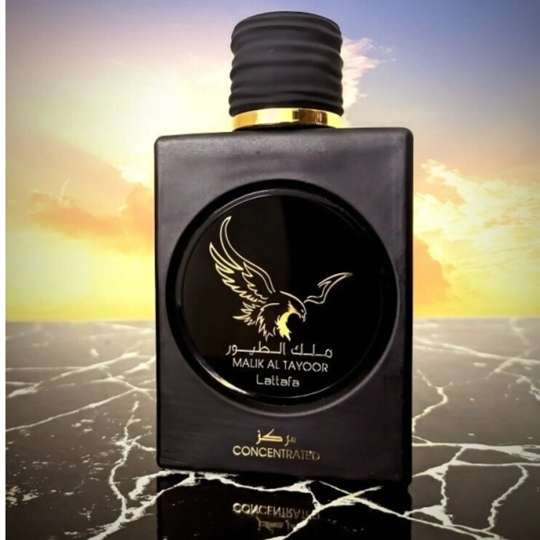 Lattafa Malik Al Tayoor Concentrated 100ml — Black perfume bottle and its black textured box with a golden eagle emblem and Arabic text, set against a white background. | Lattafa Malik Al Tayoor Concentrated 100ml — Botol minyak wangi hitam dan kotaknya yang bertekstur hitam dengan lambang helang emas dan teks Arab