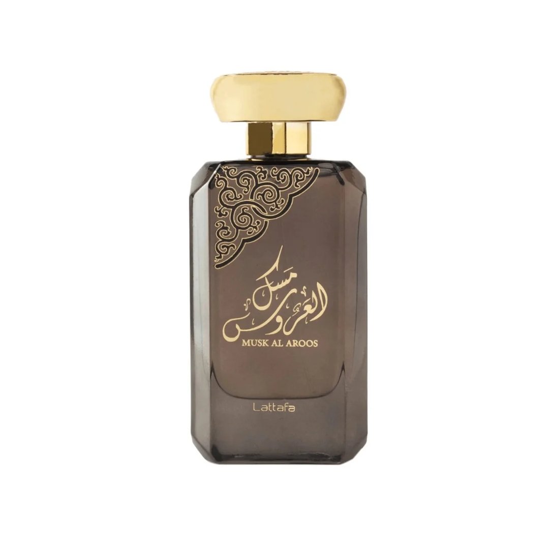 Lattafa Musk Al Aroos by Lattafa 80ml EDP — A black perfume box with gold ornate cutouts and Arabic calligraphy sits next to a dark glass perfume bottle with a gold cap and matching ornate design. | Lattafa Musk Al Aroos by Lattafa 80ml EDP — Kotak minyak wangi hitam dengan potongan berukir emas dan kaligrafi Arab
