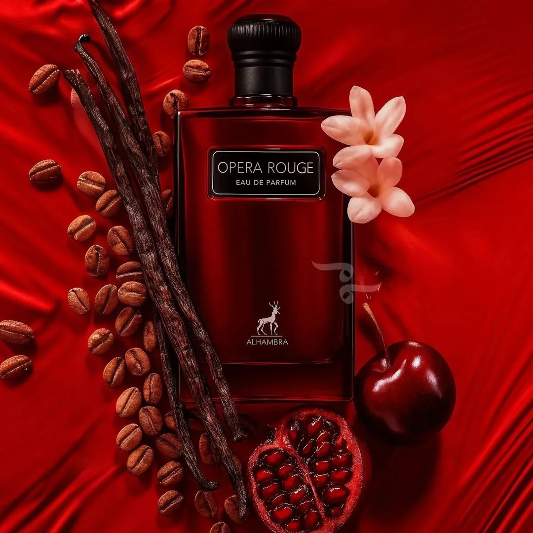 Maison Alhambra Opera Rouge — A deep red, rectangular perfume bottle with a black textured cap and a silver label reading "OPERA ROUGE EAU DE PARFUM" and a deer logo below, stands next to its matching black and red box. | Maison Alhambra Opera Rouge — Botol minyak wangi berbentuk segi empat berwarna merah pekat dengan