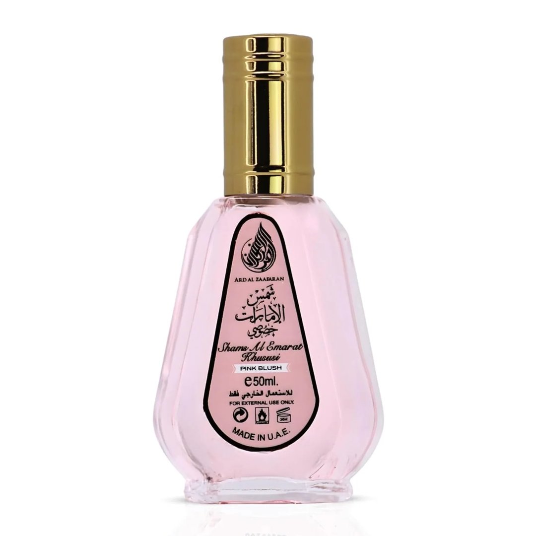 Ard Al Zaafaran Pink Blush Shams Al Emarat Khususi 50ml Perfume — Pink glass perfume bottle with gold spray nozzle and cap, label shows Arabic script and English text, isolated on white background.