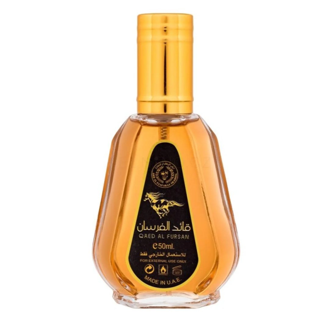 Ard Al Zaafaran Qaed Al Fursan — A gold-capped glass perfume bottle with amber liquid sits next to its black and gold box featuring a running horse graphic. | Ard Al Zaafaran Qaed Al Fursan — Botol kaca bertutup emas dengan cecair berwarna ambar duduk bersebelahan dengan kotak hitam dan emasnya yang menampilkan grafik
