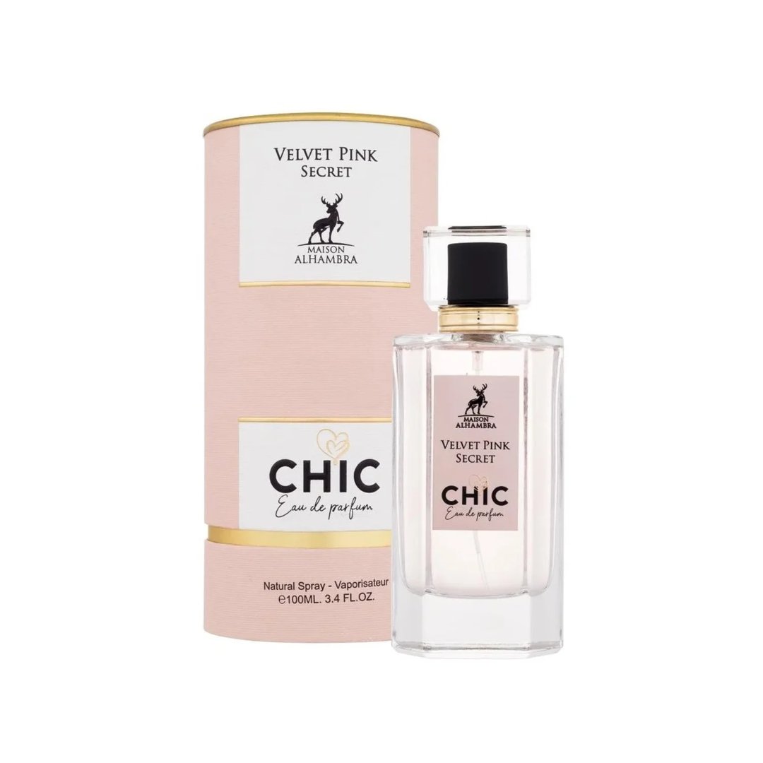 Maison Alhambra Chic Velvet Pink Secret for Women 100ml — A pink cylindrical box stands next to a clear glass perfume bottle with a black cap and gold accents. The box and bottle label feature a deer silhouette and text. | Maison Alhambra Chic Velvet Pink Secret for Women 100ml — Kotak silinder merah jambu berdiri di