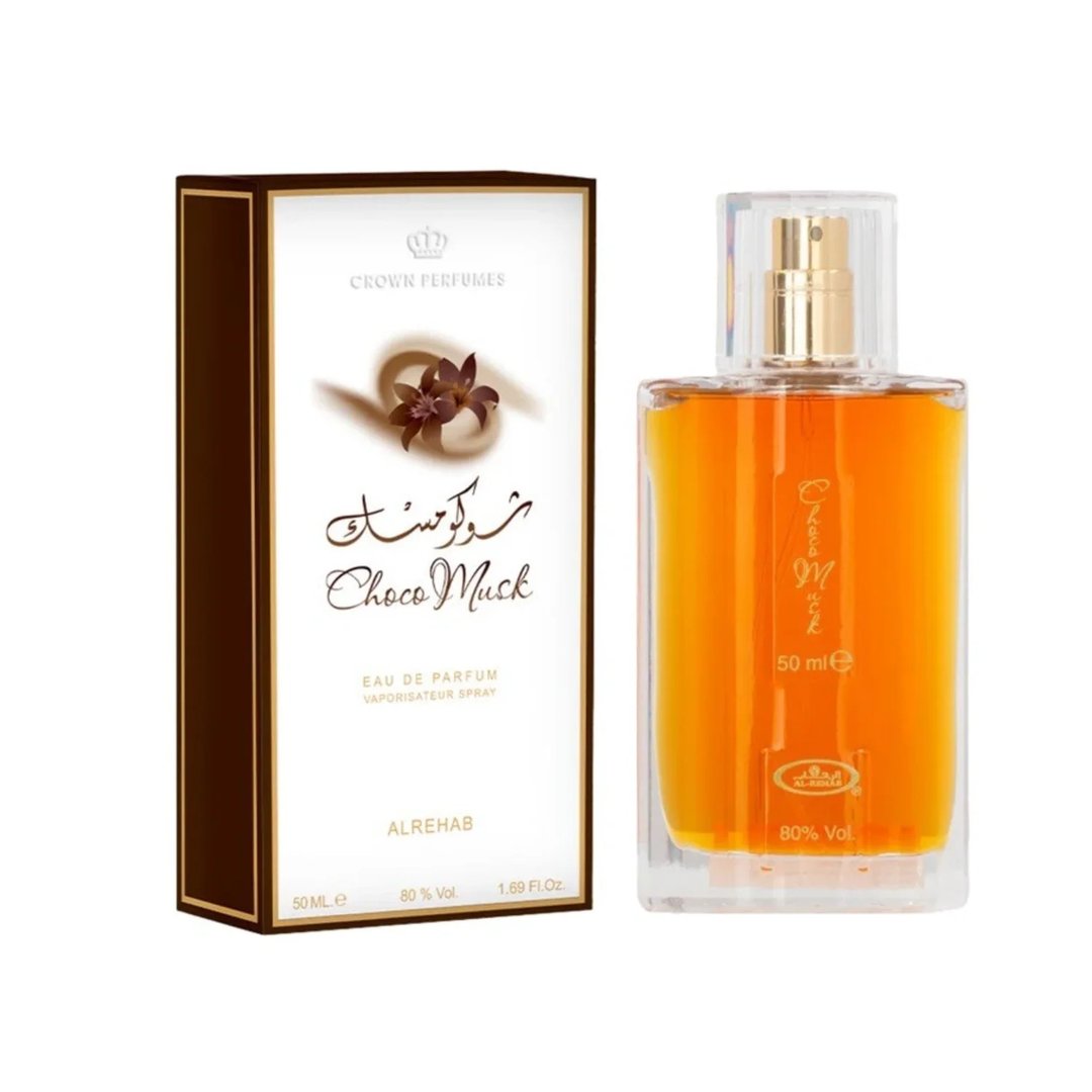 Al Rehab Choco Musk — A perfume box and bottle are displayed against a white background. The box is brown and white with floral and text details. The clear glass bottle contains amber liquid. | Al Rehab Choco Musk — Kotak dan botol minyak wangi dipaparkan berlatarkan putih. Kotak berwarna coklat dan putih dengan