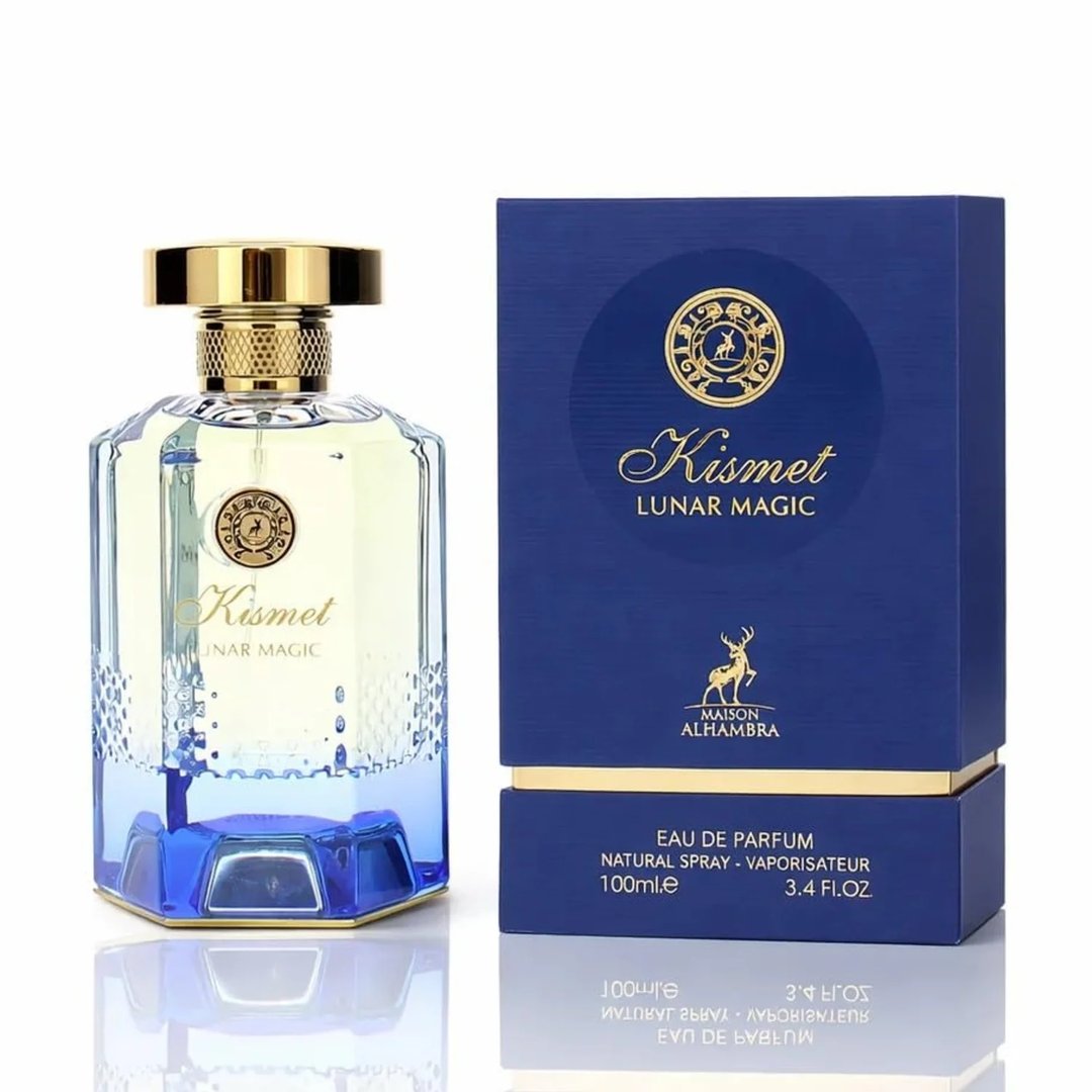 Maison Alhambra Kismet Lunar Magic 100ml — A clear glass perfume bottle with a gold cap and blue gradient base sits next to its matching blue and gold box on a white background. | Maison Alhambra Kismet Lunar Magic 100ml — Botol minyak wangi kaca jernih dengan penutup emas dan tapak gradien biru terletak di sebelah