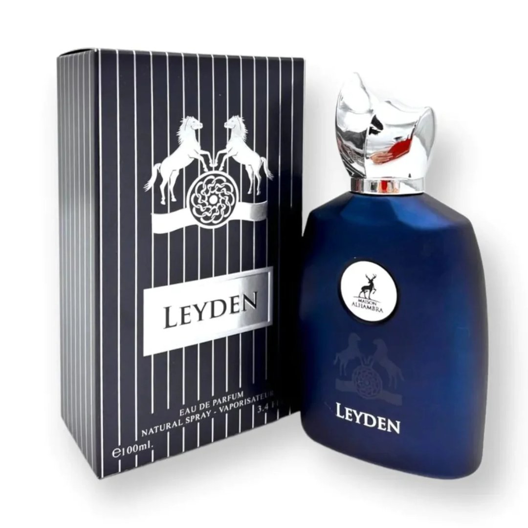 Maison Alhambra Leyden Eau De Parfum — A dark blue perfume bottle and its matching striped box are displayed side-by-side against a white background. The box features two white horses and a circular emblem. | Maison Alhambra Leyden Eau De Parfum — Botol minyak wangi biru gelap dan kotaknya yang berjalur dipamerkan