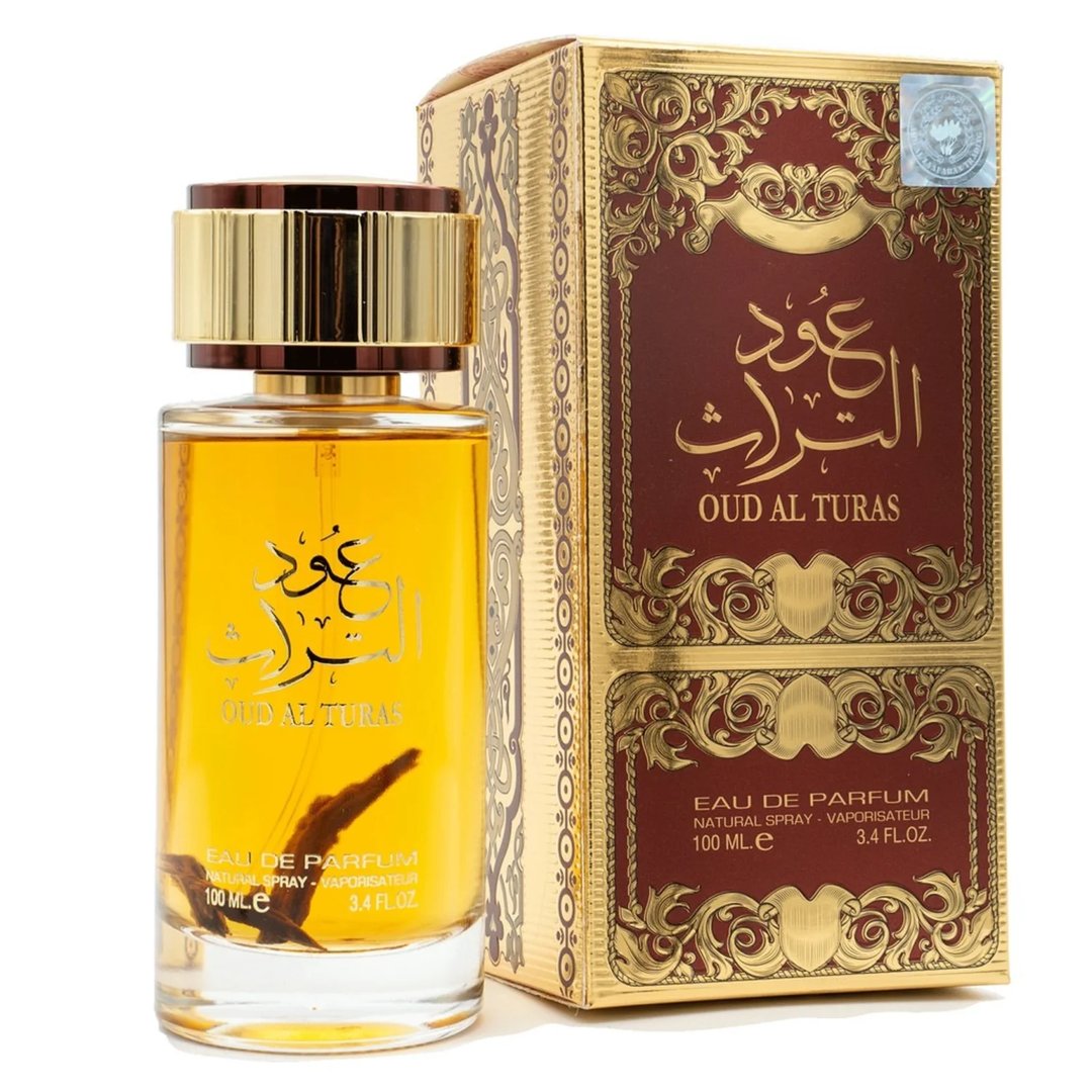 Ard Al Zaafaran Oud Al Turas — A clear glass perfume bottle with golden cap and a dark dried plant inside, next to a gold and maroon ornate box. | Botol minyak wangi kaca jernih dengan penutup emas dan tumbuhan kering gelap di dalamnya, bersebelahan dengan kotak berhias emas dan merah marun.