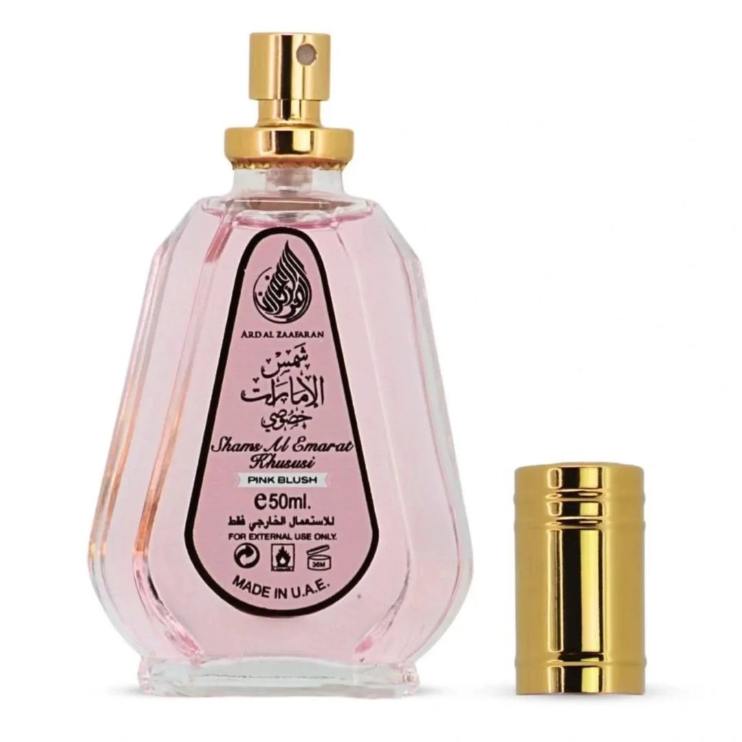 Ard Al Zaafaran Pink Blush Shams Al Emarat Khususi 50ml Perfume — Pink glass perfume bottle with gold spray nozzle and cap, label shows Arabic script and English text, isolated on white background.