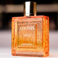 Rayhaan Adonis Icarus Perfume — A gold embossed box sits next to a square amber glass perfume bottle with a gold cap, both featuring intricate embossed patterns. | Rayhaan Adonis Icarus Perfume — Kotak emas bertekstur duduk bersebelahan botol minyak wangi kaca berwarna ambar berbentuk segi empat dengan penutup emas