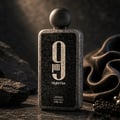 Afnan 9 PM Night Out Extrait de Parfum — A black textured perfume bottle with a dark textured cap stands next to its matching black textured box, both featuring a large white '9 PM Night Out' logo. | Afnan 9 PM Night Out Extrait de Parfum — Botol minyak wangi bertekstur hitam dengan penutup bertekstur gelap berdiri di