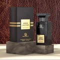 Grandeur Amber Leather 100ml by Grandeur Perfumes — A dark glass perfume bottle with a gold label sits next to its black and gold striped box on a white background. | Grandeur Amber Leather 100ml oleh Grandeur Perfumes — Botol minyak wangi kaca gelap dengan label emas duduk di sebelah kotaknya yang berjalur hitam dan