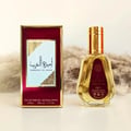 Ard Al Zaafaran Ameerat Al Arab Princess of Arabia 50ml — A red and gold perfume box stands next to a clear glass perfume bottle with a gold cap and a red label. | Ard Al Zaafaran Ameerat Al Arab Princess of Arabia 50ml — Kotak minyak wangi merah dan emas berdiri di sebelah botol minyak wangi kaca jernih dengan