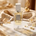 Lattafa Ana Abiyedh Leather 60ml by Lattafa Perfumes — A white perfume box with gold Arabic calligraphy and a clear glass bottle with gold accents and a dark brown cap, displayed side-by-side. | Lattafa Ana Abiyedh Leather 60ml by Lattafa Perfumes — Kotak minyak wangi putih dengan kaligrafi Arab emas dan botol kaca