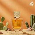 Lattafa Aura Lattafa 60ml EDP — A white and red box with gold line art is displayed next to a clear glass perfume bottle with a gold patterned cap, both featuring the Lattafa Aura branding. | Lattafa Aura Lattafa 60ml EDP — Kotak putih dan merah dengan seni garis emas dipamerkan di sebelah botol minyak wangi kaca