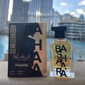 Ard Al Zaafaran Bashaara Eau De Parfum 100ml — Clear glass bottle with yellow liquid and black text "BA SHAARA" repeated vertically, black wooden cap | Ard Al Zaafaran Bashaara Eau De Parfum 100ml — Botol kaca jernih dengan cecair kuning dan teks hitam "BA SHAARA" berulang secara menegak, penutup kayu hitam