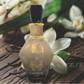 Grandeur Cashmere Luxe 100ml by Grandeur — A faceted glass perfume bottle with a black gem-like cap and a black tassel hanging from the neck, against a white background. | Grandeur Cashmere Luxe 100ml by Grandeur — Botol kaca berfaset dengan penutup seperti permata hitam dan juntai hitam tergantung di lehernya