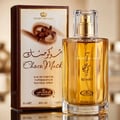 Al Rehab Choco Musk — A perfume box and bottle are displayed against a white background. The box is brown and white with floral and text details. The clear glass bottle contains amber liquid. | Al Rehab Choco Musk — Kotak dan botol minyak wangi dipaparkan berlatarkan putih. Kotak berwarna coklat dan putih dengan