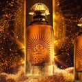 Paris Corner Daar Al Oud Intense 100ml — Black box with gold sunburst and Arabic script next to a glass perfume bottle with gold cap and matching design | Paris Corner Daar Al Oud Intense 100ml — Kotak hitam dengan pancaran matahari emas dan tulisan Arab di sebelah botol minyak wangi kaca dengan penutup emas dan reka