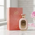 Zimaya Daiman Eden Eau De Parfum 100ml by Zimaya — A pink textured perfume bottle with gold accents stands next to its matching coral-orange textured box with gold marbling. | Zimaya Daiman Eden Eau De Parfum 100ml by Zimaya — Sebotol minyak wangi merah jambu bertekstur dengan perincian emas berdiri di sebelah kotak