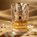 Lattafa Dalal Lattafa 100ml Women — Perfume bottle with ornate gold filigree cap, adorned with rhinestones, next to its white and gold box with matching filigree design.