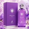 Maison Alhambra Delilah Viola 100ml — A purple glass perfume bottle with a gold cap stands next to its matching purple box, both featuring gold embossed details and a deer logo. | Maison Alhambra Delilah Viola 100ml — Botol kaca ungu berdiri di sebelah kotak ungu sepadan, kedua-duanya menampilkan butiran emas timbul