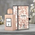 Maison Alhambra Floral Bloom — A beige perfume bottle with a peach cap stands next to its matching beige box, both featuring floral and deer motifs. | Maison Alhambra Floral Bloom — Botol minyak wangi berwarna krim dengan penutup pic berdiri di sebelah kotak sepadan berwarna krim, kedua-duanya menampilkan motif bunga