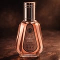 Ard Al Zaafaran Hareem Al Sultan EDP 50ml — A pink perfume bottle with a silver cap and a patterned label sits next to its matching pink and gold patterned box with a circular purple design. | Ard Al Zaafaran Hareem Al Sultan EDP 50ml — Sebotol minyak wangi merah jambu dengan penutup perak dan label bercorak terletak