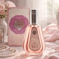 Ard Al Zaafaran Hareem Al Sultan EDP 50ml — A pink perfume bottle with a silver cap and a patterned label sits next to its matching pink and gold patterned box with a circular purple design. | Ard Al Zaafaran Hareem Al Sultan EDP 50ml — Sebotol minyak wangi merah jambu dengan penutup perak dan label bercorak terletak