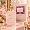 RASASI Hawas Glitz by Rasasi 100ml EDP — Pink perfume bottle with gold glitter accents and a textured gold cap, next to its matching pink box with a mosaic pattern.