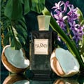 Khadlaj Island Extrait de Parfum — A perfume bottle with a dark green gradient and a gold textured cap sits next to its matching box, which features a white background with abstract green and gold marbling and palm leaf motifs. | Khadlaj Island Extrait de Parfum — Botol minyak wangi dengan gradien hijau gelap dan