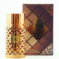 Ard Al Zaafaran Jazzab Gold Eau De Parfum 100ml — A gold-toned perfume bottle with a diamond-patterned cage sits next to its matching patterned box on a white background. | Ard Al Zaafaran Jazzab Gold Eau De Parfum 100ml — Botol minyak wangi berwarna emas dengan sangkar bermotif berlian duduk bersebelahan dengan kotak