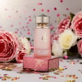 Paris Corner Khair Fusion Her 100ml — Red and gold patterned box next to a frosted pink perfume bottle with a gold textured cap. | Paris Corner Khair Fusion Her 100ml — Kotak corak merah dan emas di sebelah botol minyak wangi merah jambu beku dengan penutup bertekstur emas.