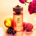 Paris Corner Khair Fusion Her 100ml — Red and gold patterned box next to a frosted pink perfume bottle with a gold textured cap. | Paris Corner Khair Fusion Her 100ml — Kotak corak merah dan emas di sebelah botol minyak wangi merah jambu beku dengan penutup bertekstur emas.