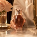 Zimaya Kibria Glory — Rose gold perfume bottle with crown cap and matching textured box, both featuring embossed Arabic script and 'KIBRIA GLORY' text.