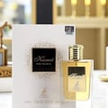 Maison Alhambra Kismet for Women 100ml by Maison Alhambra — A white box and a clear glass perfume bottle with gold accents and a deer emblem, displayed against a white background. | Maison Alhambra Kismet for Women 100ml by Maison Alhambra — Peti putih dan botol minyak wangi kaca jernih dengan perincian emas dan