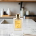 Maison Alhambra Kismet for Women 100ml by Maison Alhambra — A white box and a clear glass perfume bottle with gold accents and a deer emblem, displayed against a white background. | Maison Alhambra Kismet for Women 100ml by Maison Alhambra — Peti putih dan botol minyak wangi kaca jernih dengan perincian emas dan